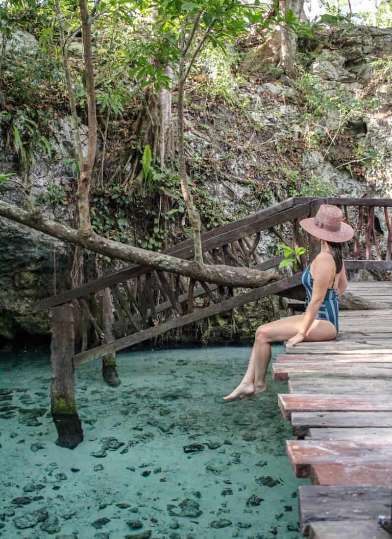 girl sitting on a staircase in the grand cenote tulum