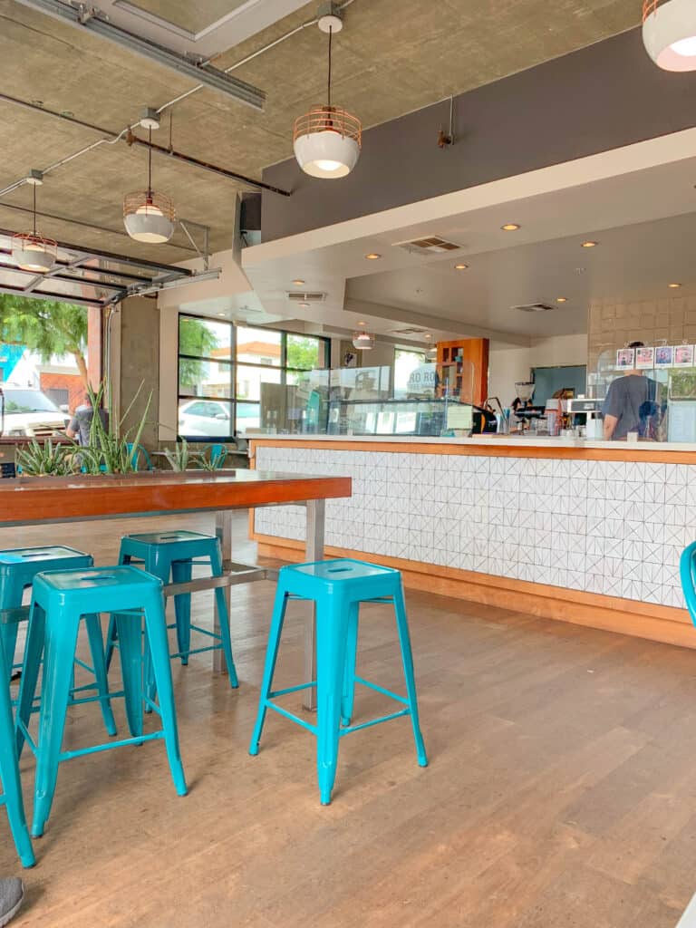 clean and modern coffee shop with bright blue stools