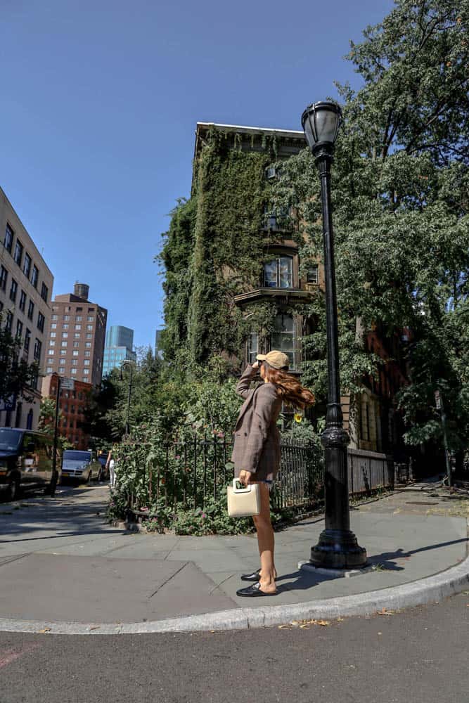 girl waving hair in front of ivy-covered building in lower manhattan
