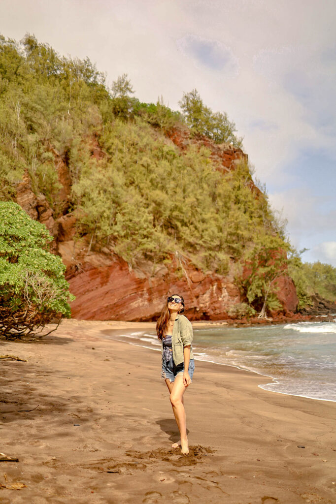 girl posing on the red sand beach in maui