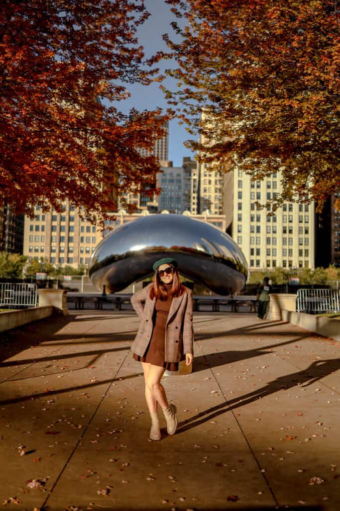 girl in standing in front of the bean in millennium park during fall