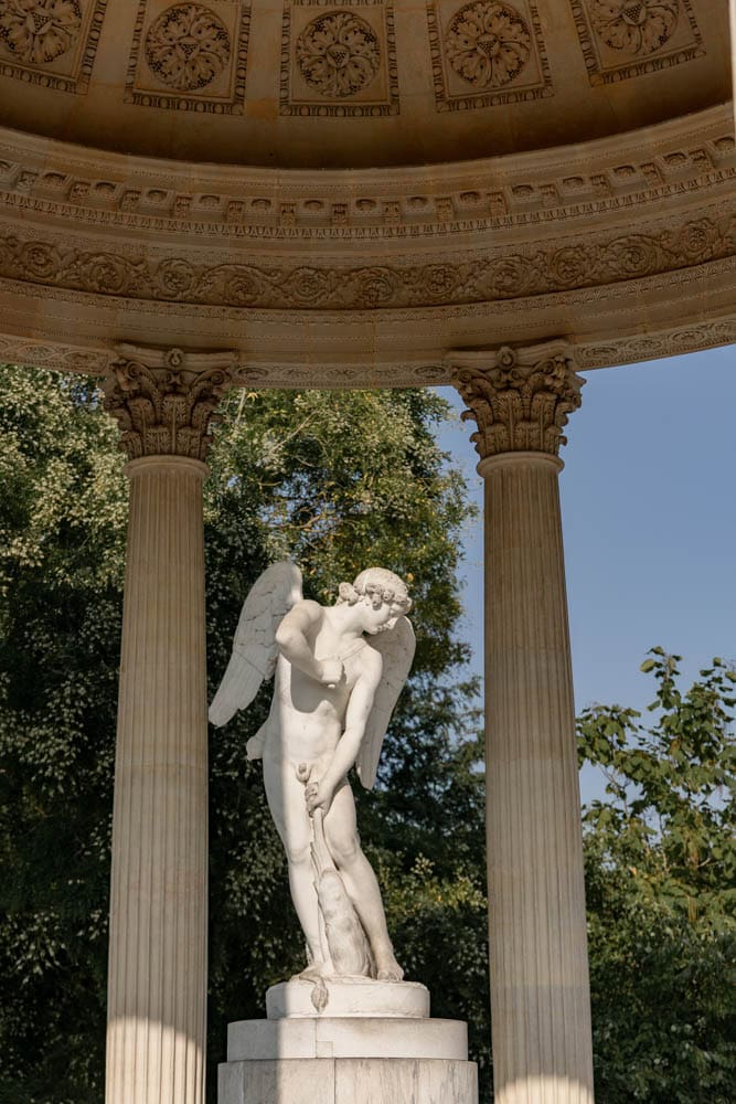 statue surrounded by a temple in the gardens of Versailles