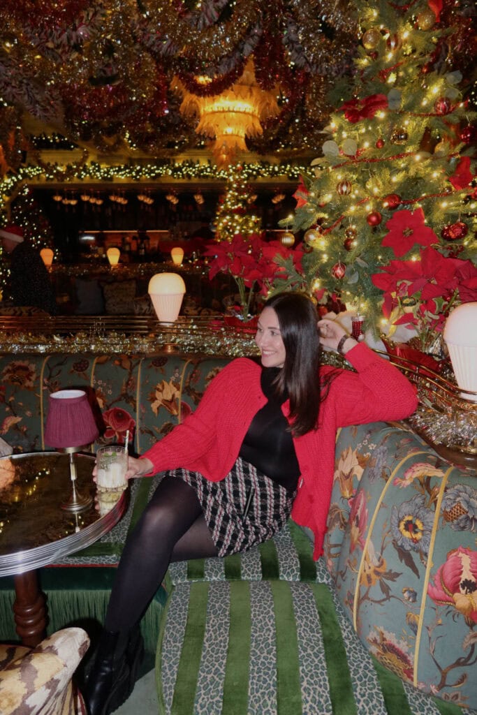 Festive Christmas decorated interior with hanging ornaments, Christmas trees, and elegant seating.