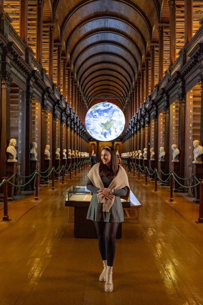 woman standing in Trinity College Library in Dublin with Globe