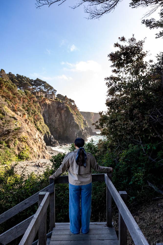 girl standing on wooden stairs overlooking private beach at Heritage House in Mendocino