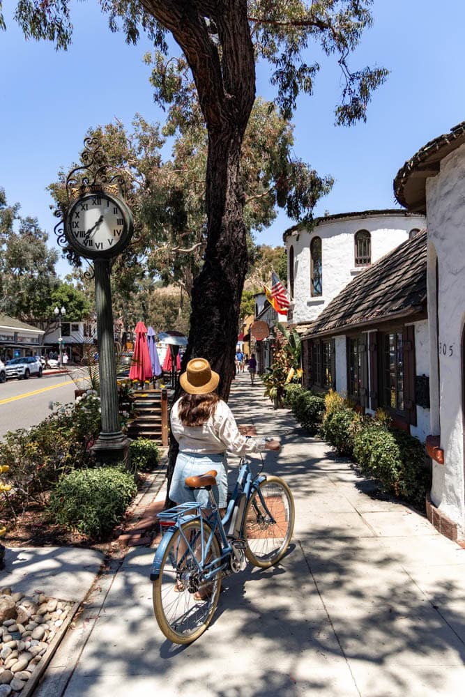 woman standing next to bike in charming town of Laguna Beach