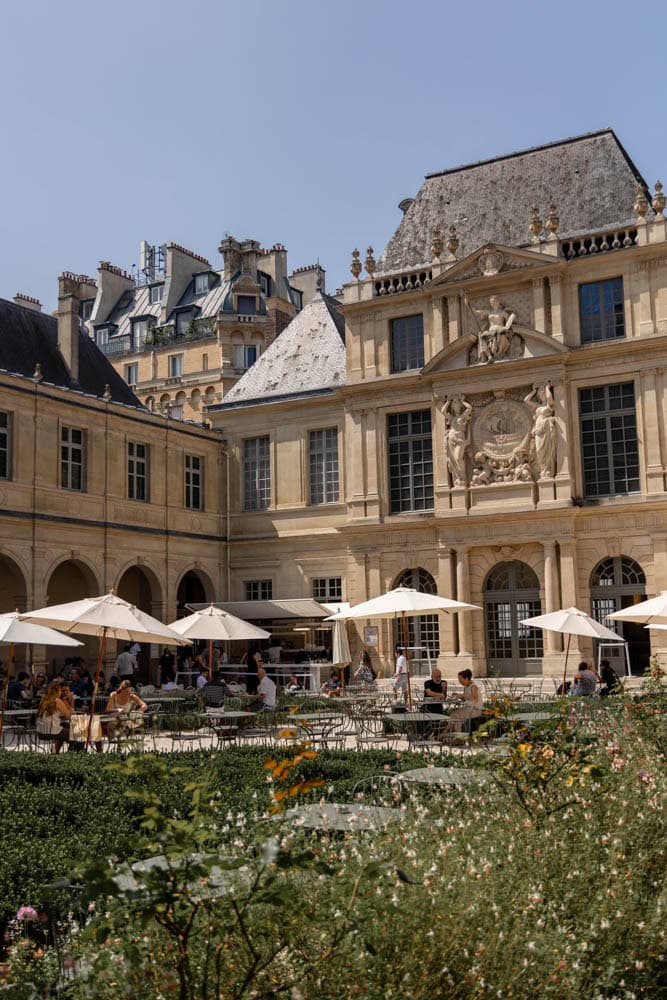 courtyard of a museum with white umbrellas and a cafe