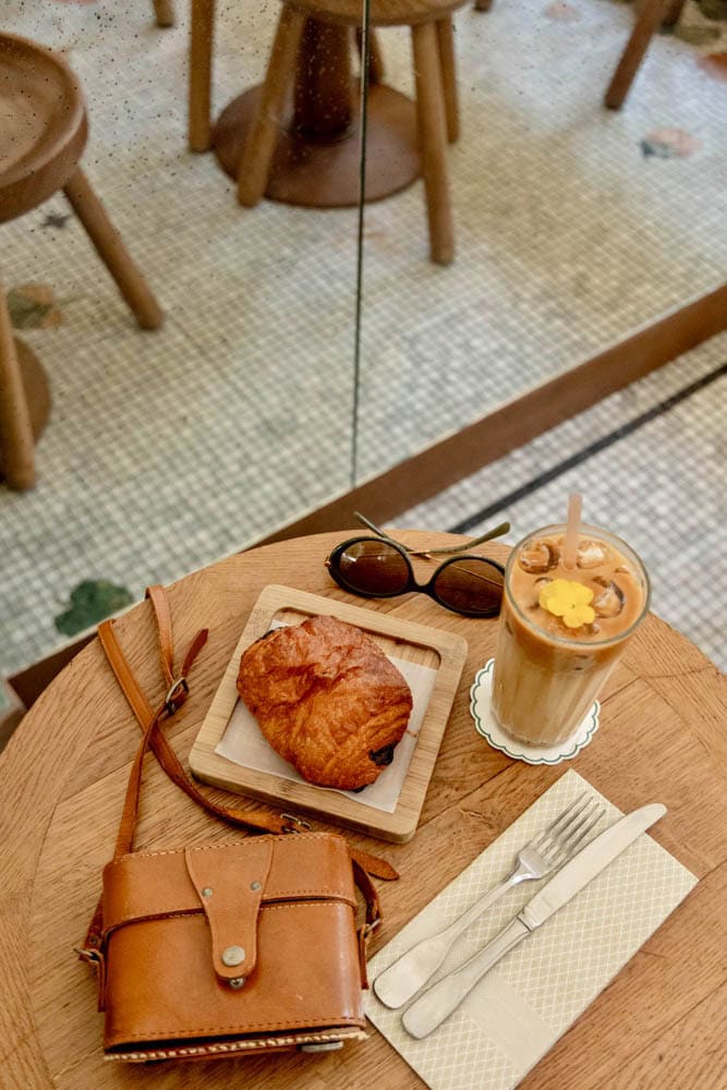 pain au chocolat with an iced latte and checkered floors
