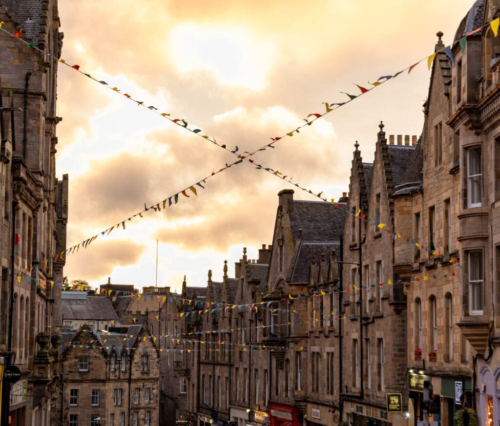 Colorful bunting decorates historic city streets at sunset.