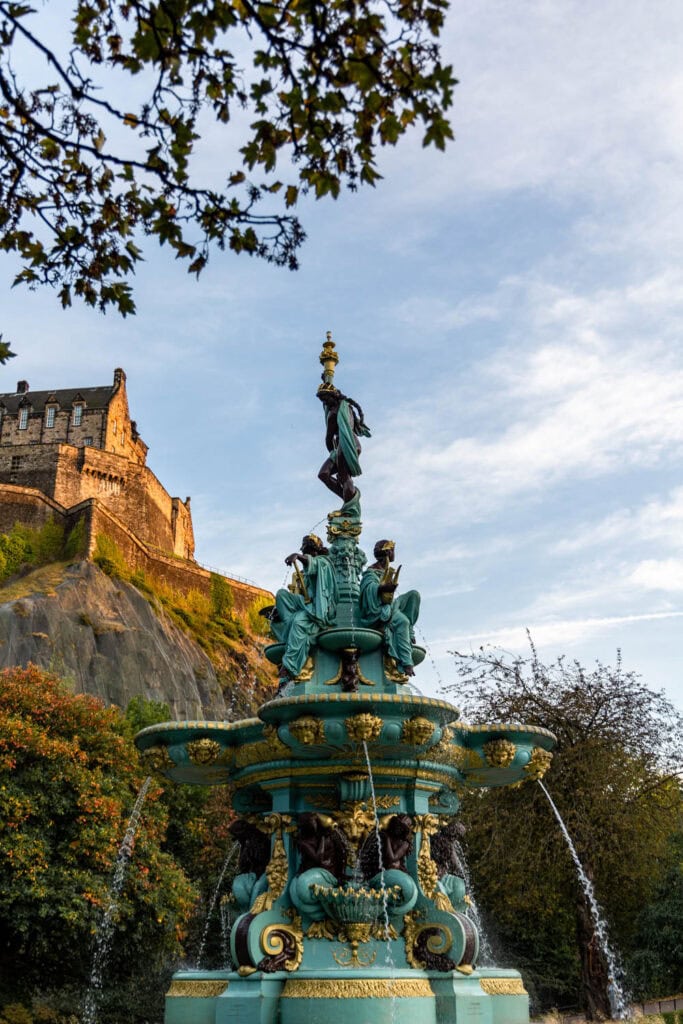 Intricate blue and gold historic fountain in Edinburgh with castle in background, perfect for travel photography.