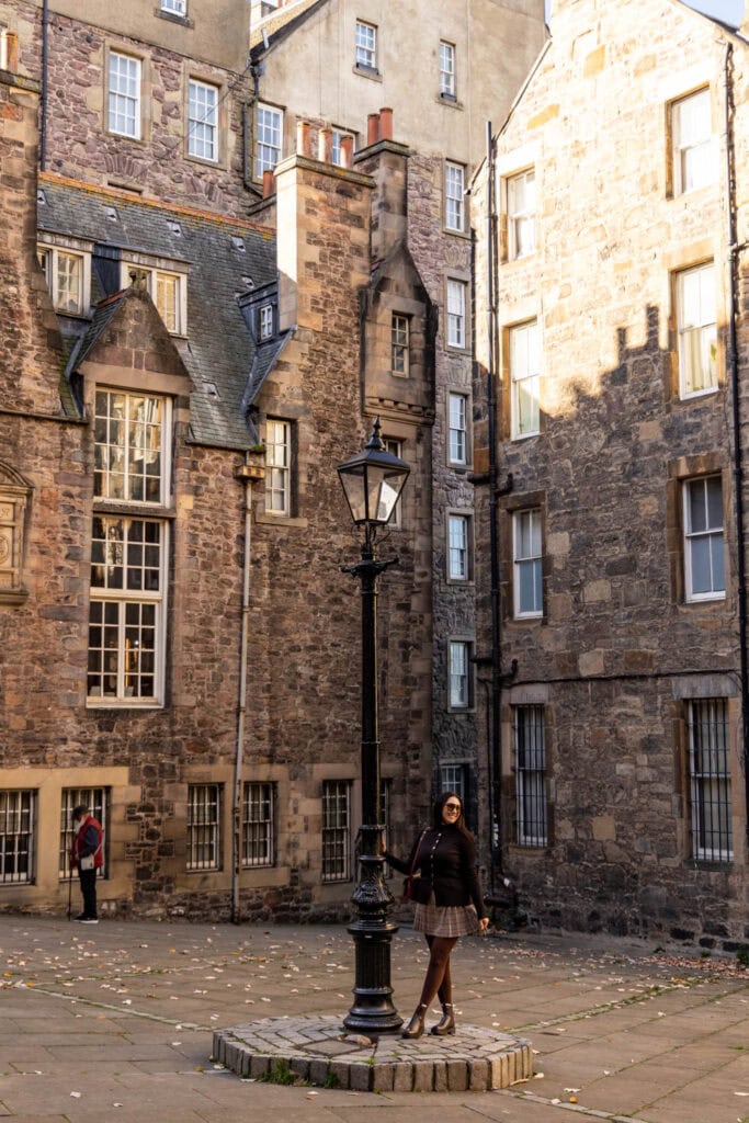 woman standing near a lamp post in a courtyard in Edinburgh