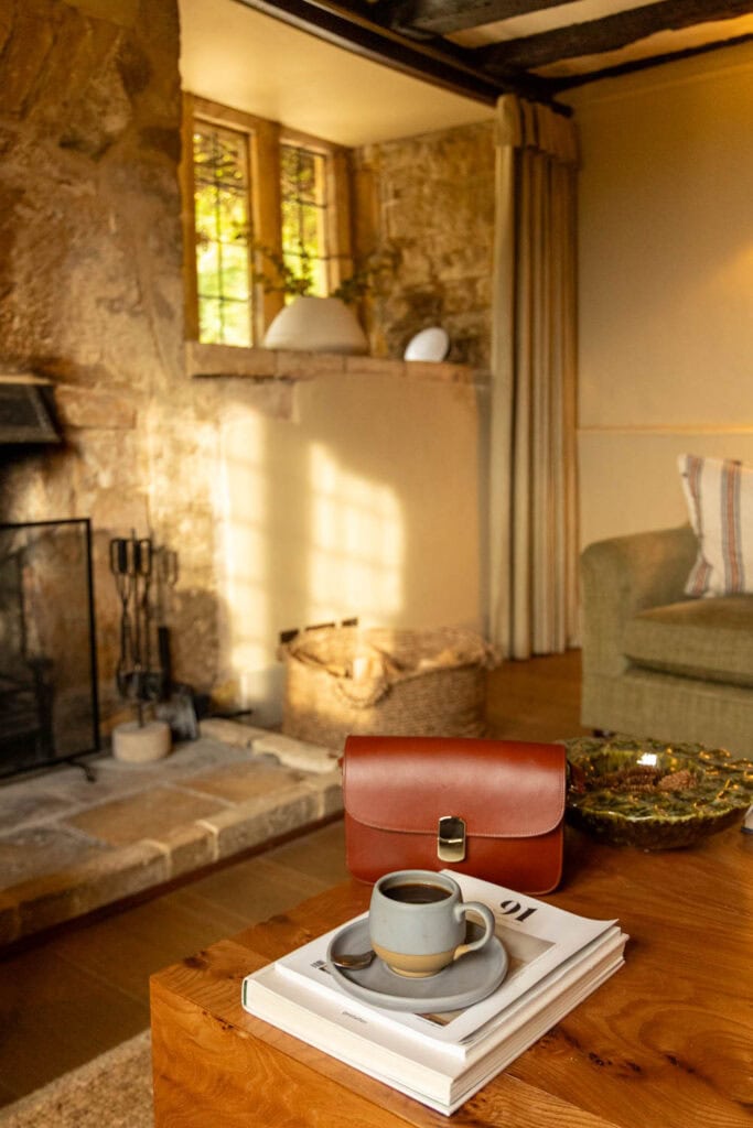 Bright room featuring large windows, warm lighting, and coffee table with books.
