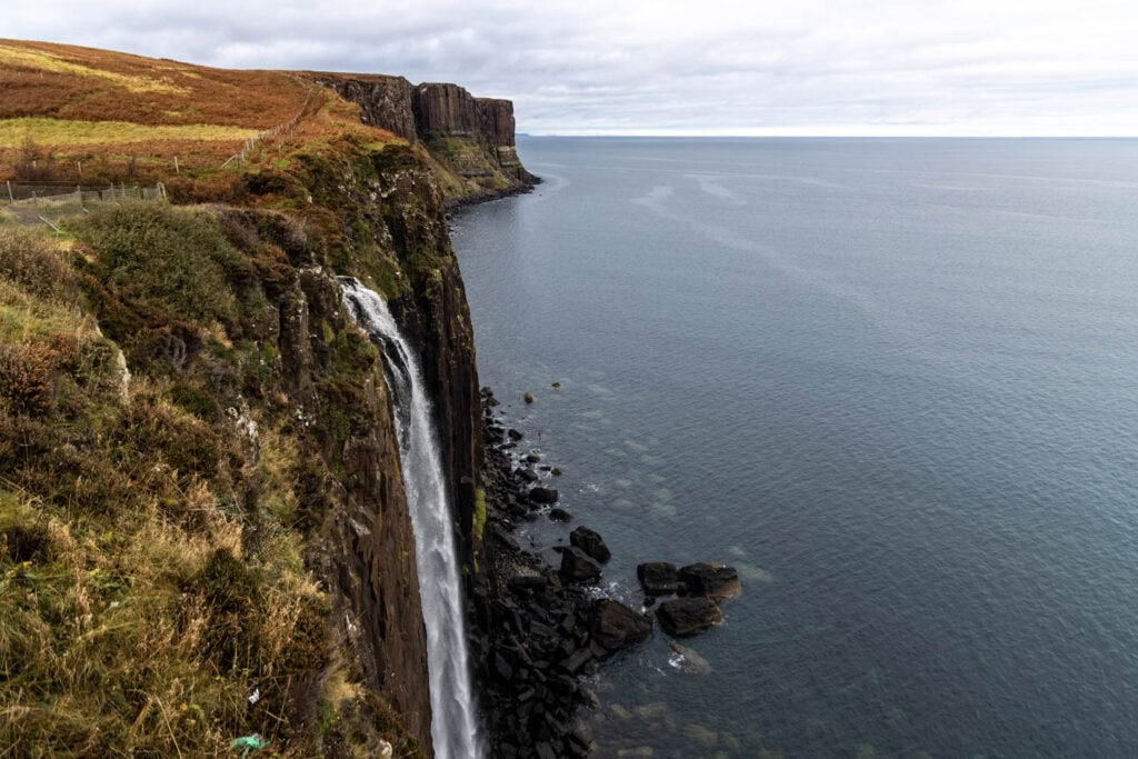 Breathtaking coastal cliffs with waterfall view, rugged terrain, and ocean scenery on the Isle of Skye