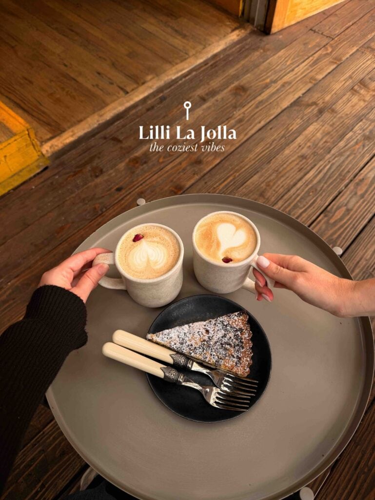 Two hands holding coffee cups with latte art on a tray.