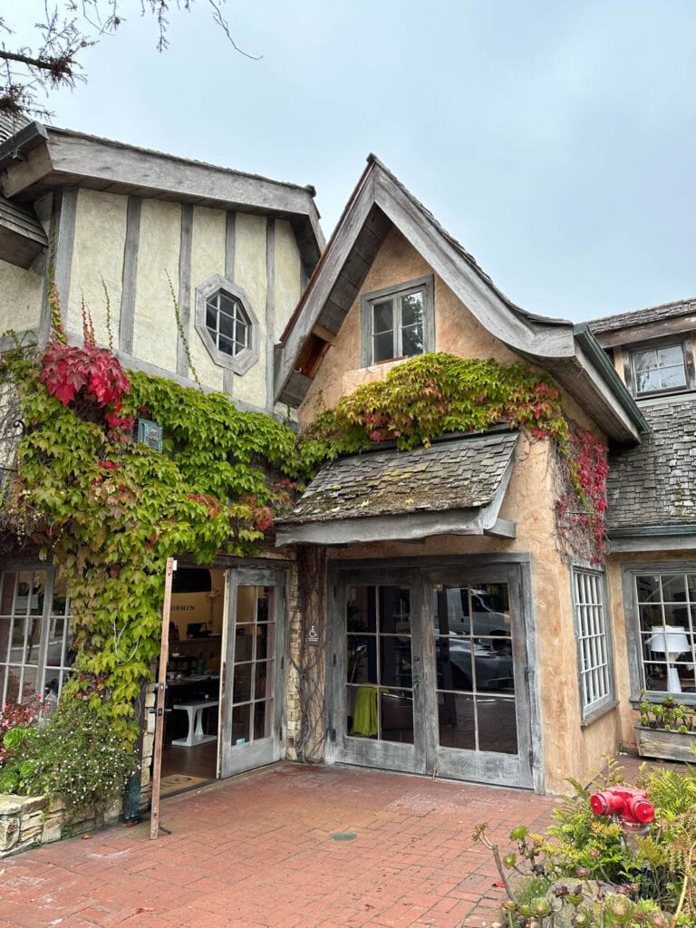 Cozy Carmel-by-the-Sea cottage with ivy-covered walls and vibrant flowers.