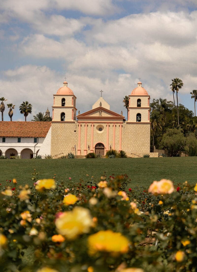 Mission Church with twin bell towers and surrounding garden.