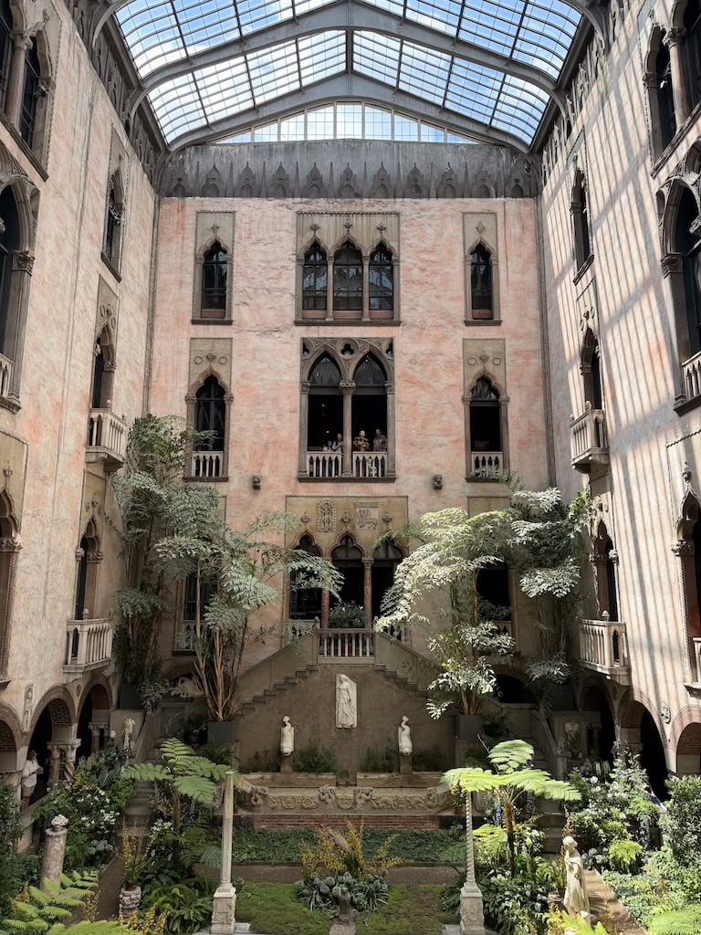 Elegant historic building with lush indoor garden and glass ceiling.