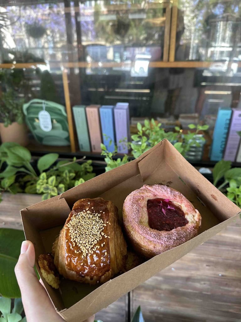 Freshly baked fruit-filled pastries in a cardboard box, on a wooden table.