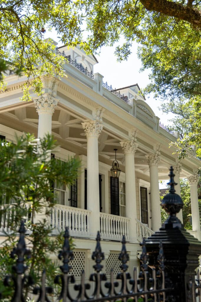 Beautiful historic mansion with white columns and lush greenery.