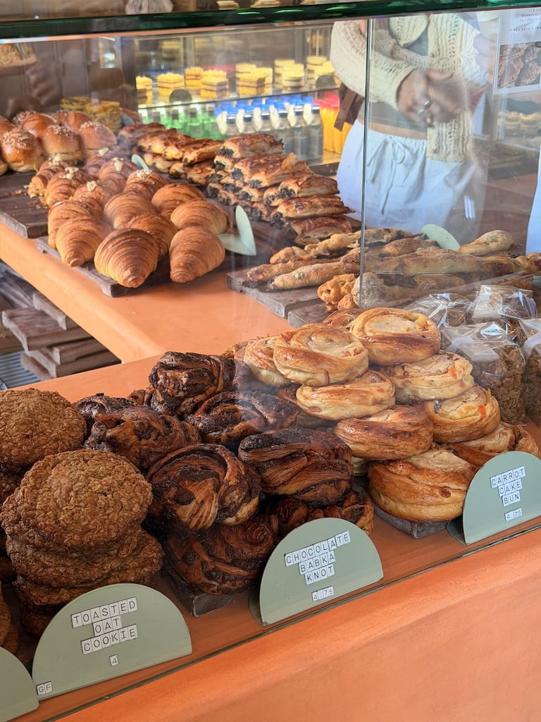 Assorted baked goods including croissants, cookies, and pastries at a bakery.