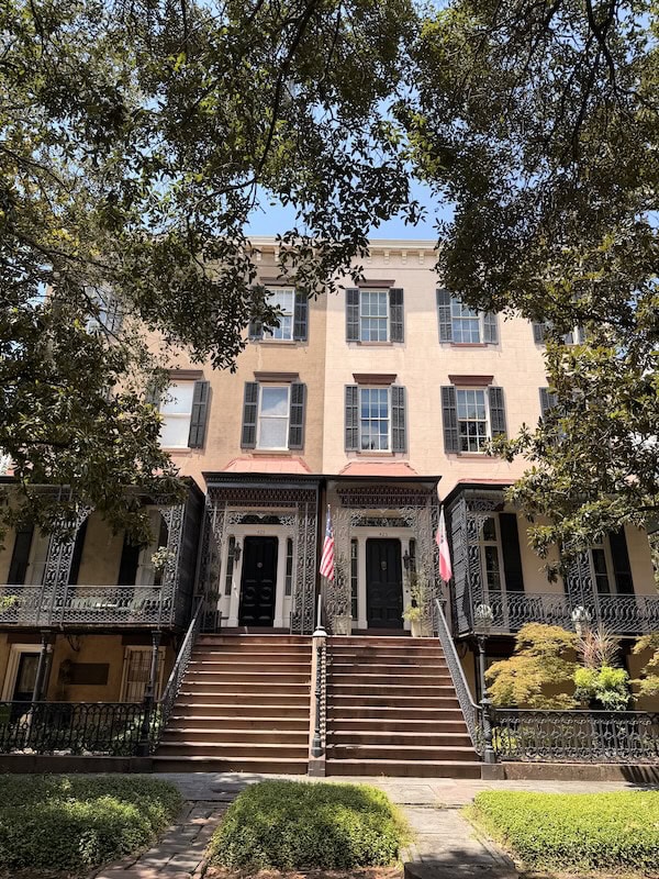 Elegant historic building with staircase and American flags in front.