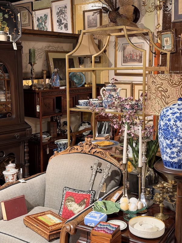 Vintage furniture and decorative items in an antique shop setting.